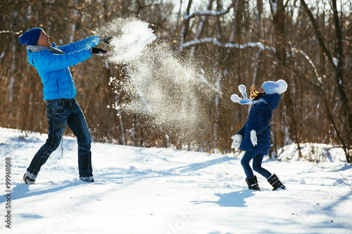 father and daughter playing in the snow in winter