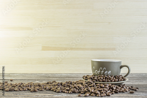 Cup of coffee with beans standing on a wooden table