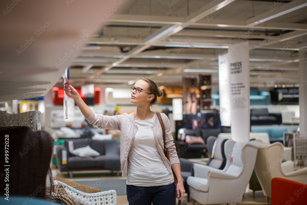 Pretty, young woman choosing the right furniture for her apartme Pretty, young woman choosing the right furniture for her apartme
