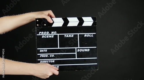 Hands use movie production clapper board, on black photo