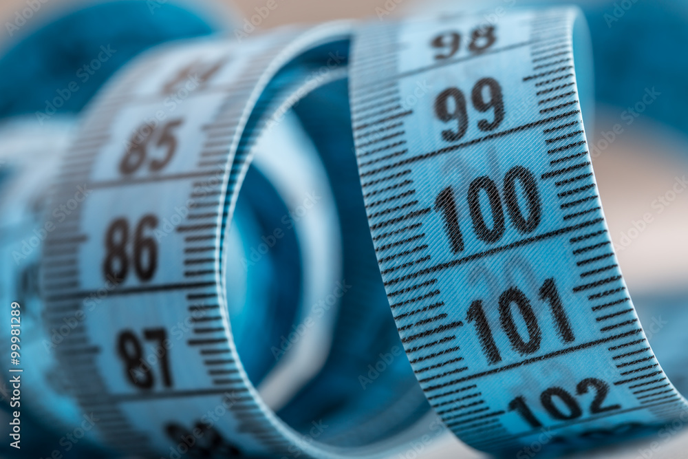 Curved measuring tape. Measuring tape of the tailor. Closeup view of blue measuring tape. Curved measuring tape. Measuring tape of the tailor. Closeup view of blue measuring tape.