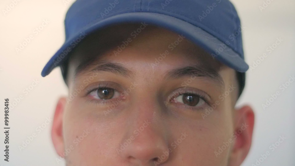 Slow motion of a man eyes taking off a baseball hat Slow motion of a man eyes taking off a baseball hat