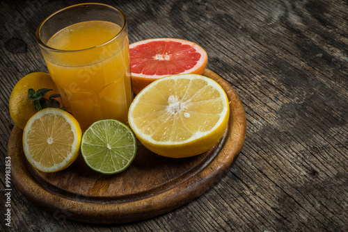 Juice glass and fresh citrus fruit on rustic wood.Fresh healthy
