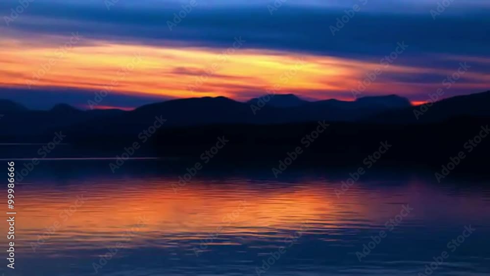 Time lapse of a sunset behind the silhouette of a mountain ridge in the Inside Passage, Alaska. Time lapse of a sunset behind the silhouette of a mountain ridge in the Inside Passage, Alaska.