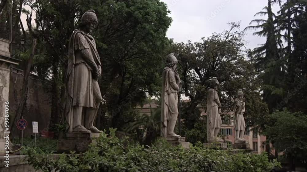 Single Roman statues in a green garden Single Roman statues in a green garden