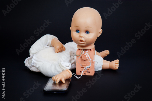 defective talking doll with his hand on a mobile phone
