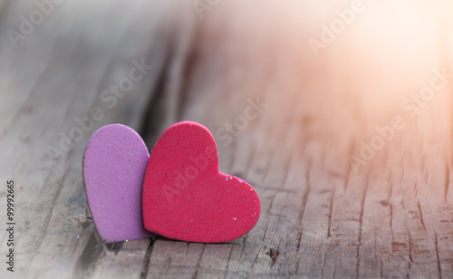 Red and purple hearts on old wooden background