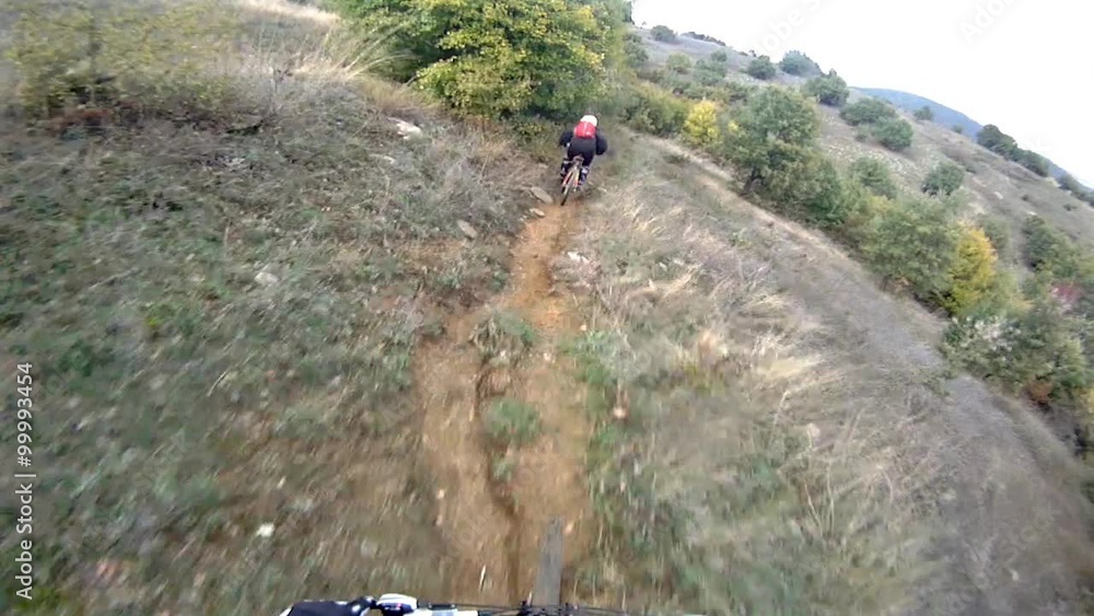 Mountain bikers POV racing through the Mountain bikers POV racing through the