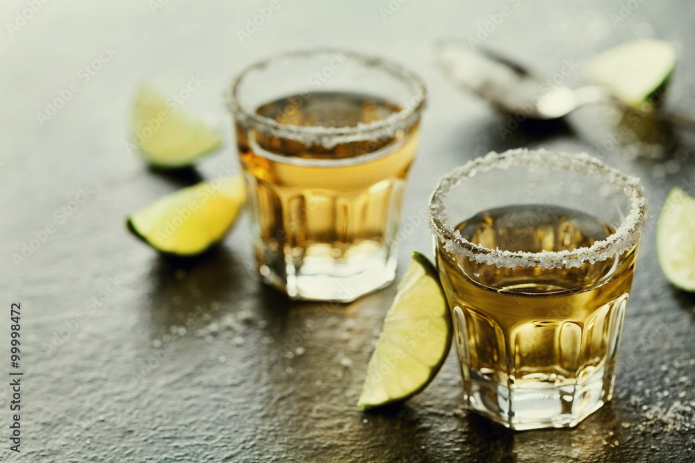 Tequila shot with lime and sea salt on black table, selective focus Tequila shot with lime and sea salt on black table, selective focus