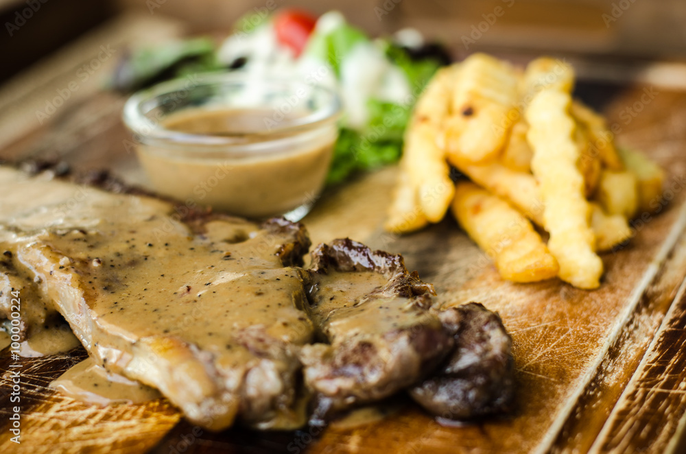 Striploin Steak with salt and pepper on meat cutting board Striploin Steak with salt and pepper on meat cutting board