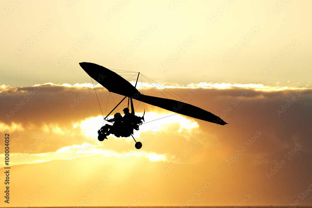 Fotografie Hang gliding in the sky at sunset
