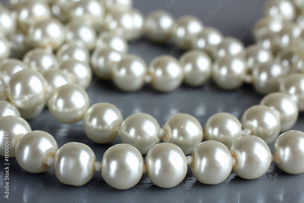 pearl beads and pearls with reflection on gray background pearl beads and pearls with reflection on gray background