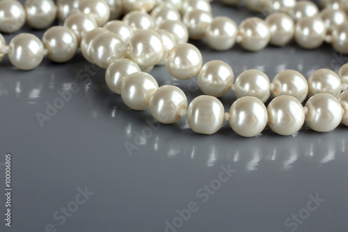 pearl beads and pearls with reflection on gray background