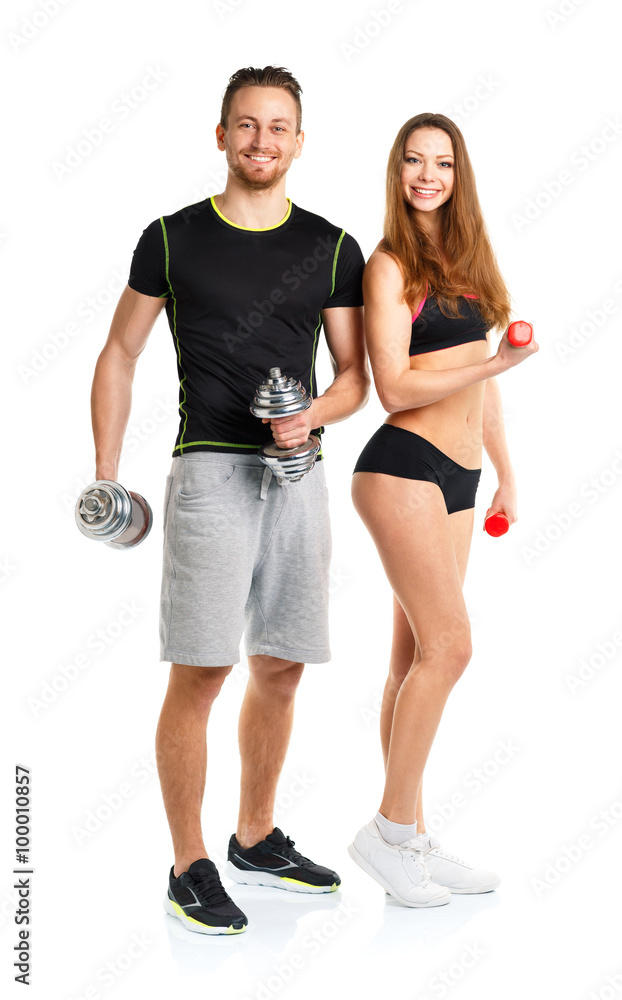 Athletic man and woman with dumbbells on the white Athletic man and woman with dumbbells on the white