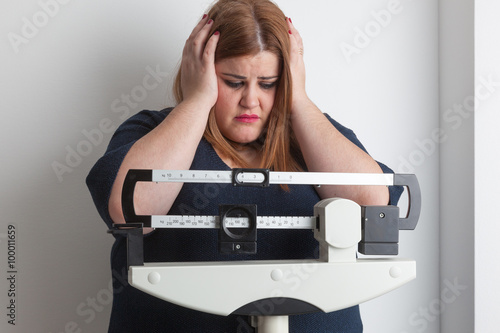 worried woman on a medical weight scale photo