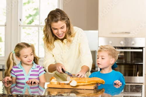 Canvas Print Happy family slicing bread