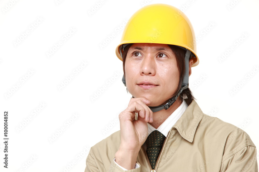 young Japanese construction worker thinks about something young Japanese construction worker thinks about something