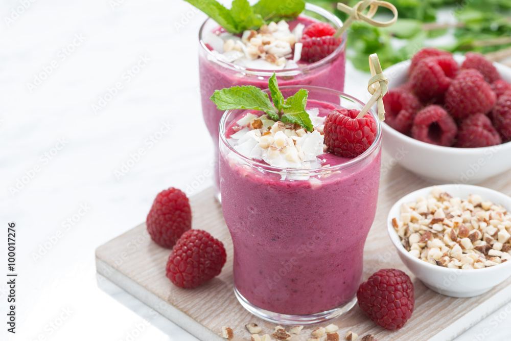 fresh berry smoothies with nuts on white board, closeup fresh berry smoothies with nuts on white board, closeup