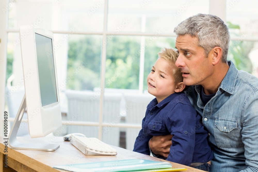 Father and son using the computer Father and son using the computer