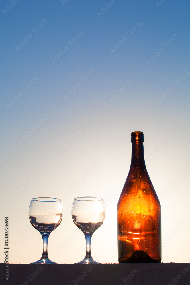 Glass and bottle with reflections of beautiful sunset. Selective Glass and bottle with reflections of beautiful sunset. Selective