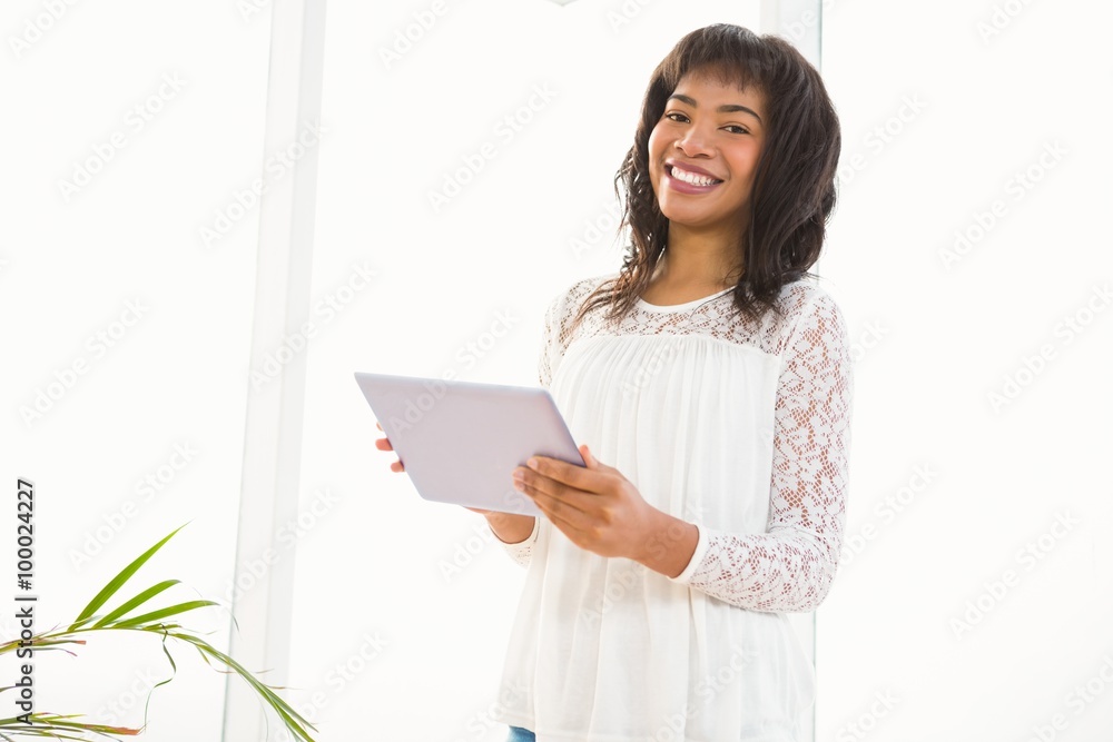 Smiling woman using her tablet in living room Smiling woman using her tablet in living room