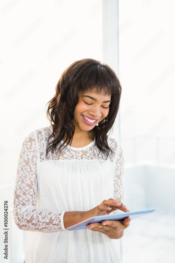 Smiling woman using her tablet in living room Smiling woman using her tablet in living room