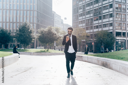 Young handsome caucasian black hair modern businessman walking i