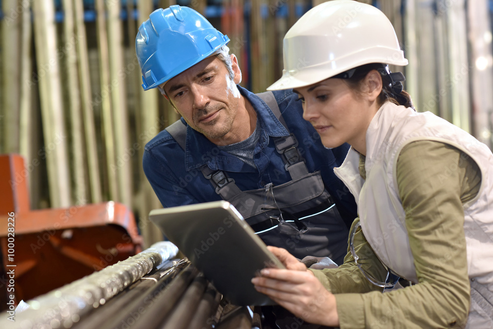 Engineers in metallurgy warehouse using digital tablet Engineers in metallurgy warehouse using digital tablet