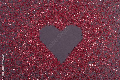 red glitter heart shape on dark ground