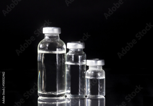 Glass Medicine Vials and Syringe on black background