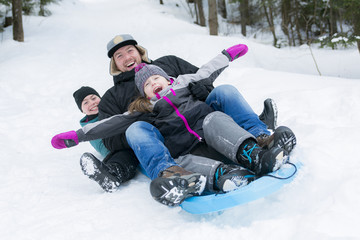 Father and son sledding at winter time