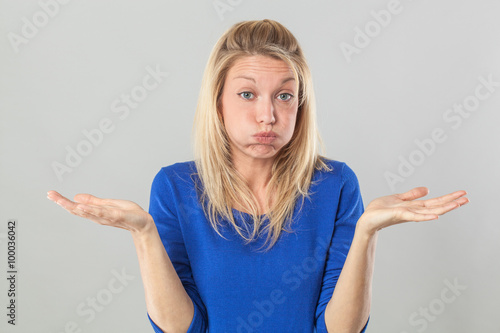 fatigue or boredom concept - frustrated young blond woman puffing her cheeks out for resignation and disillusion with hand gesture,studio shot
