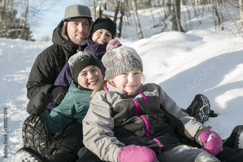 parents and daughters sledding at winter time © Louis-Photo