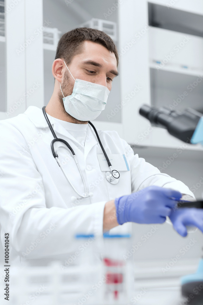 young male scientist wearing gloves in lab young male scientist wearing gloves in lab