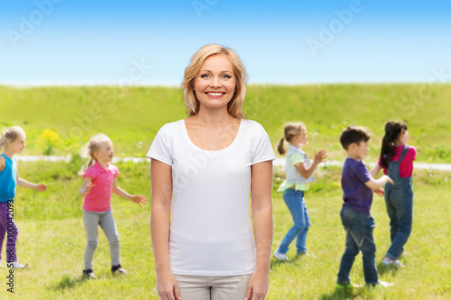 smiling woman over group of little kids outdoors