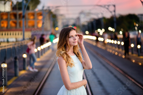 woman stands on a bridge at sunset