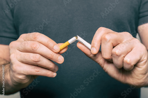 Cuadro en lienzo Quitting smoking - male hand crushing cigarette