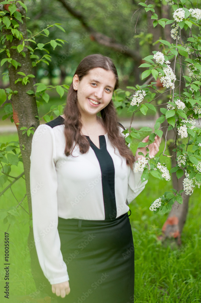 Girl schoolgirl walks in the lush spring garden after school Girl schoolgirl walks in the lush spring garden after school