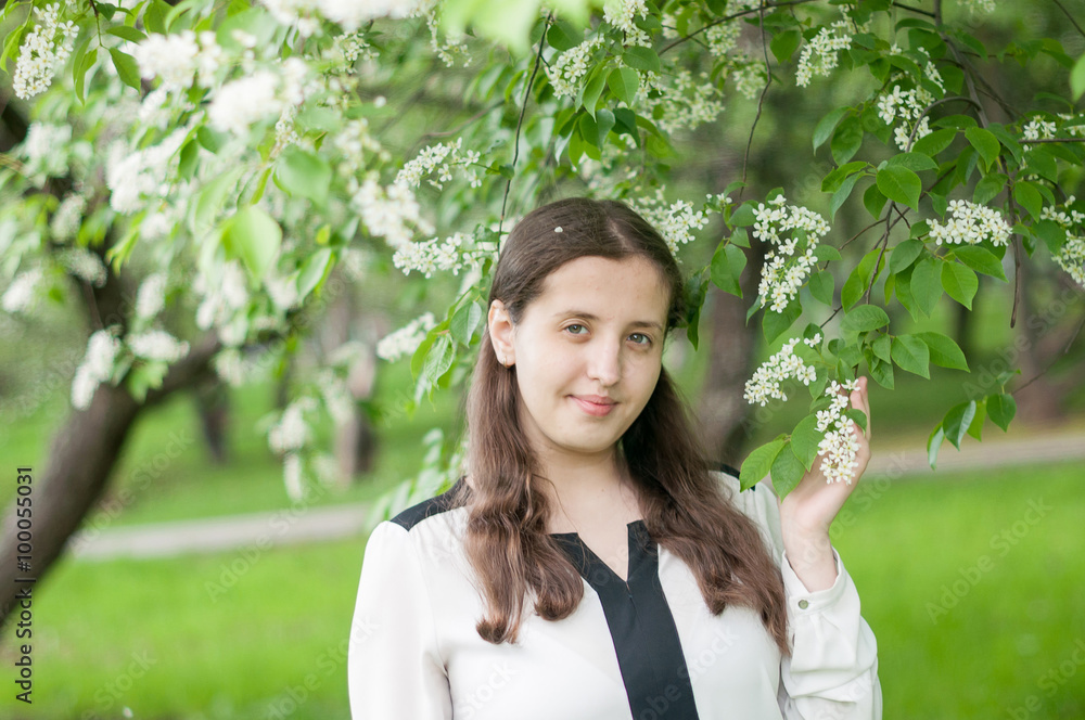 Girl schoolgirl walks in the lush spring garden after school Girl schoolgirl walks in the lush spring garden after school