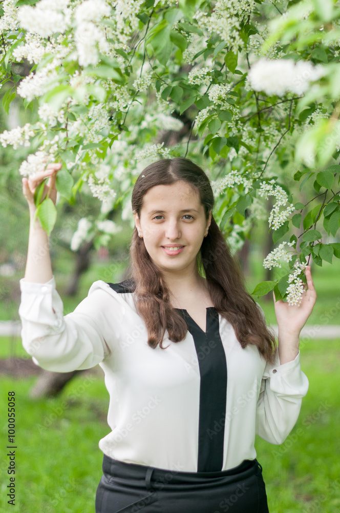 Girl schoolgirl walks in the lush spring garden after school Girl schoolgirl walks in the lush spring garden after school