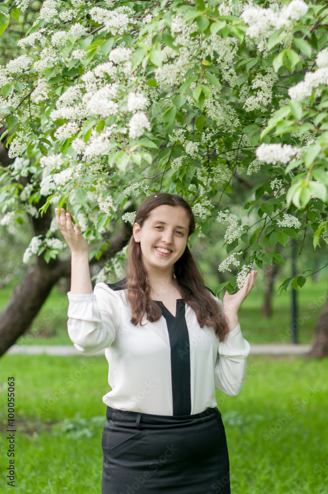 Girl schoolgirl walks in the lush spring garden after school Girl schoolgirl walks in the lush spring garden after school
