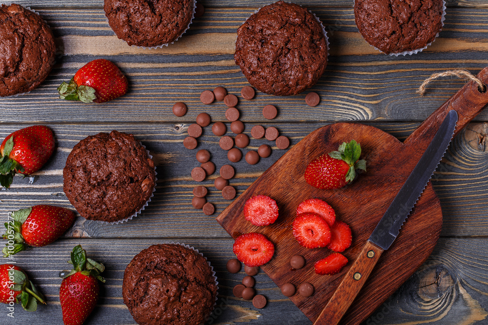 Chocolate muffins with strawberry on dark background.