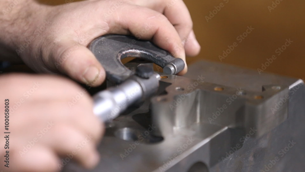 Worker the item is measured with a micrometer