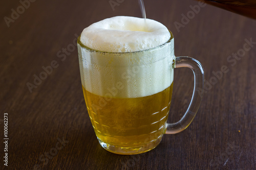 pouring beer from bottle into mug at bar