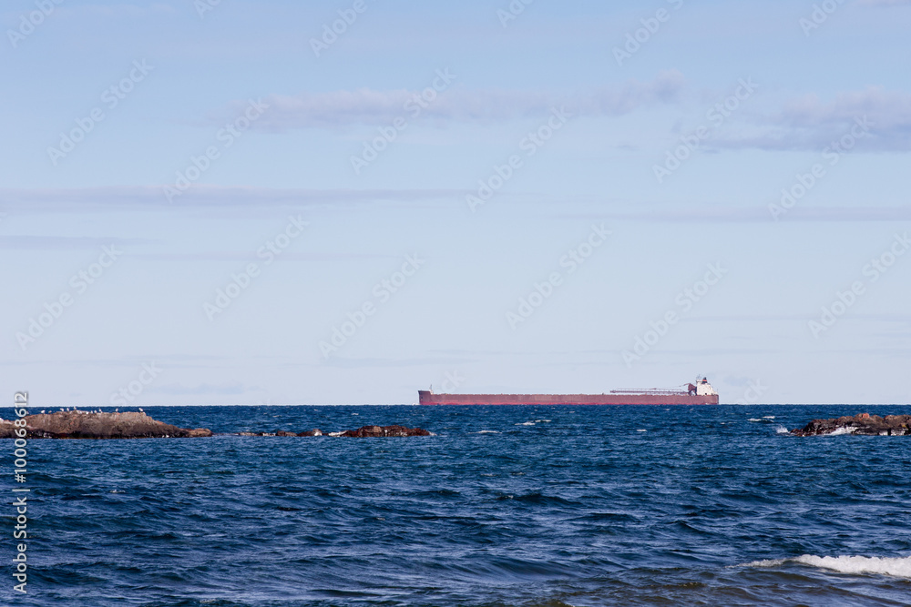 Great Lakes Freighter Passing Behind Rocky Outcroppings