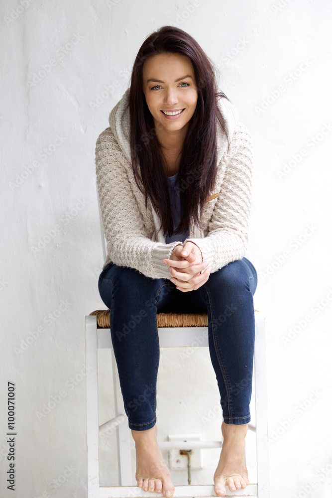 Smiling young woman sitting on chair Smiling young woman sitting on chair