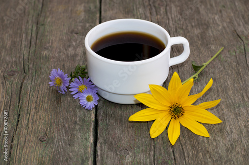 the cup of coffee decorated yellow and blue with flowers