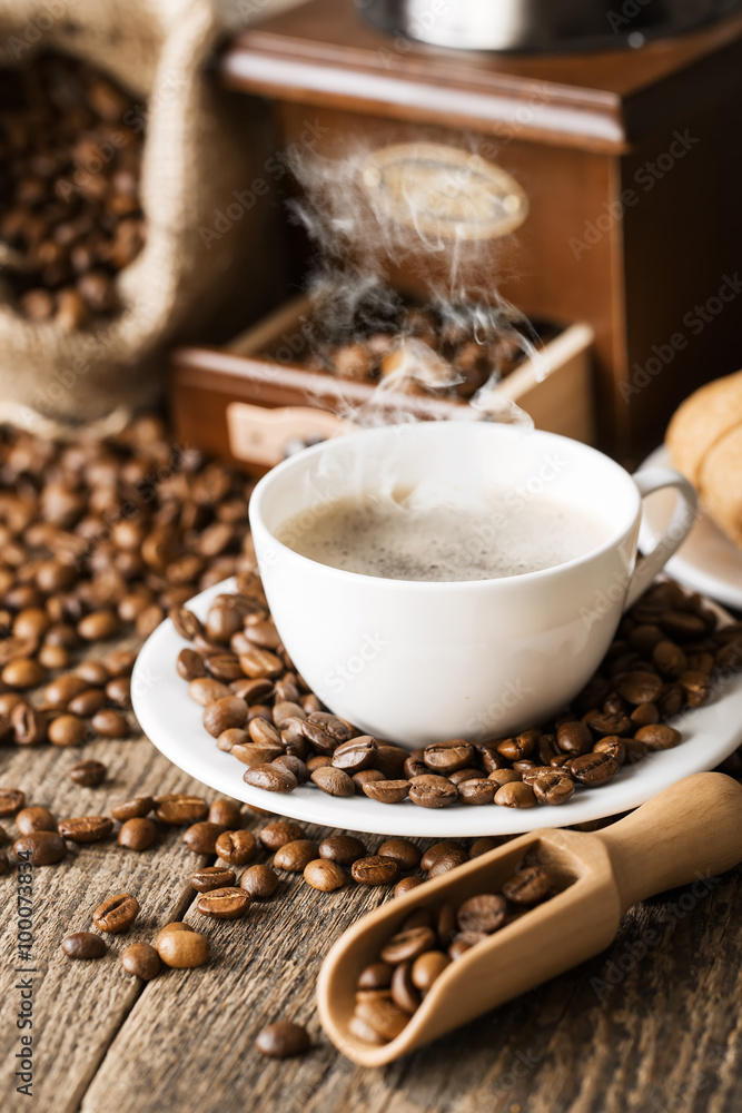 hot coffee and coffee beans on the background of coffee grinders