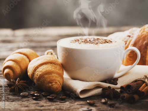 Hot coffee and pastries on a wooden background