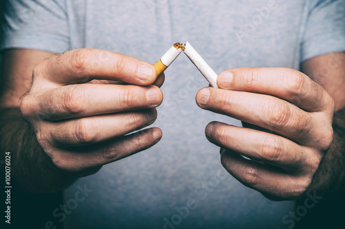 Quitting smoking - male hand crushing cigarette photo